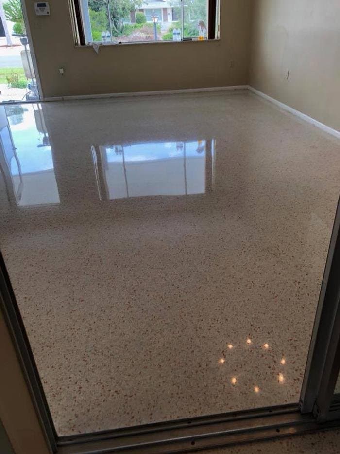 Glossy restored terrazzo floor with cream base and red aggregate in a Florida living room